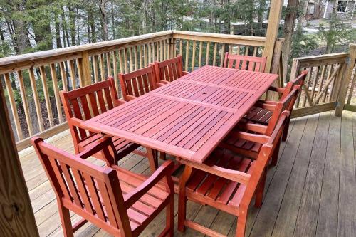 a wooden table and chairs on a deck at 4-Season Home Fireplace and Fire Pit in Barnstead in Barnstead