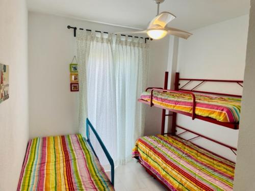 2 literas en una habitación con ventilador de techo en Precioso apartamento con ubicación perfecta en playa Islantilla, en Islantilla