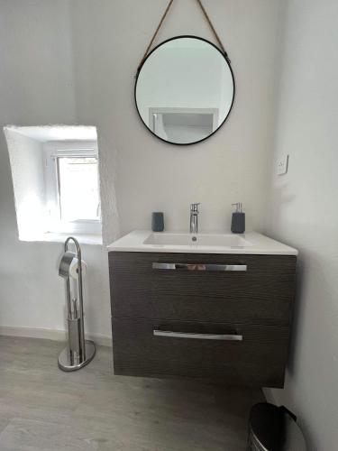 a bathroom with a sink and a mirror at Appart " la rue des roues", à Fontaine-de-Vaucluse in Fontaine-de-Vaucluse
