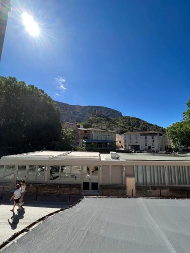 two people walking in front of a building with a train at Appart " la rue des roues", à Fontaine-de-Vaucluse in Fontaine-de-Vaucluse