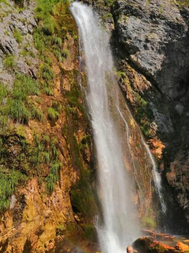 a waterfall on the side of a mountain at Bujtina Pllumi Theth in Theth