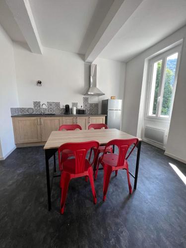 a kitchen with a table and four red chairs at Appart " la rue des roues", à Fontaine-de-Vaucluse in Fontaine-de-Vaucluse