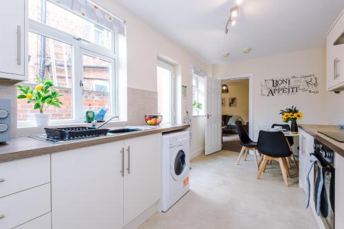 a kitchen with white cabinets and a washer and dryer at Modern apartment in Crewe by 53 Degrees Property, ideal for long-term Business & Contractors - Sleeps 4 in Crewe