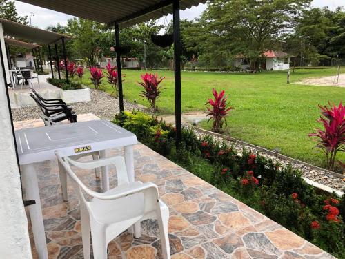 a white table and a chair in a garden at Cabañas Campestres en Villavicencio in Villavicencio