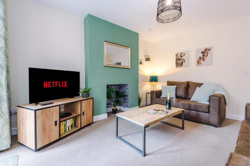 a living room with a couch and a tv at Modern apartment in Crewe by 53 Degrees Property, ideal for long-term Business & Contractors - Sleeps 4 in Crewe