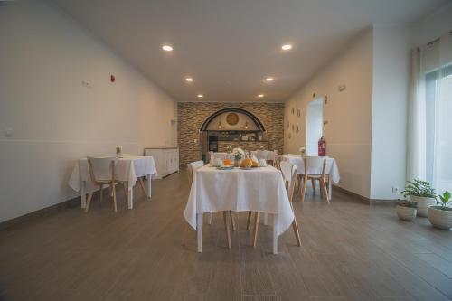 een eetkamer met witte tafels en stoelen bij Vila Rosario in Ponta Delgada