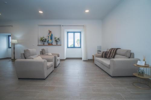 a living room with two couches and a table at Vila Rosario in Ponta Delgada