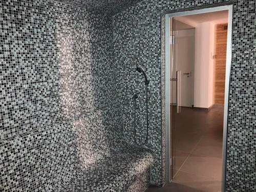 a bathroom with a shower with mosaic tile walls at Wellness & Spa Pila Kvilda AP 2 01 a AP 3 07 in Kvilda