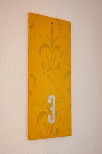 a yellow plate with a number three on a wall at Gästehaus am Schlossplatz Z. 3 in Meersburg