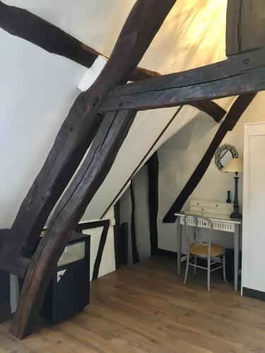 Cette chambre mansardée dispose de poutres apparentes et d'un bureau. dans l'établissement Au coin romantique Vernon Giverny, à Vernon