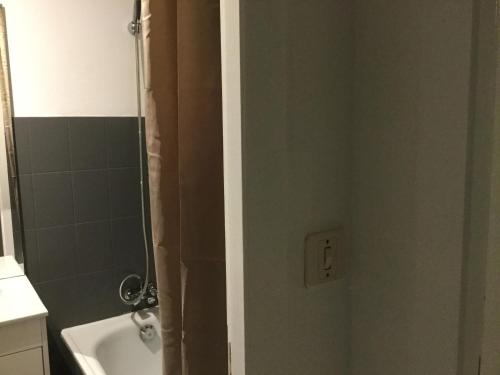 une salle de bain avec un rideau de douche et un lavabo dans l'établissement T1 parc paysager St Nazaire, à Saint-Nazaire