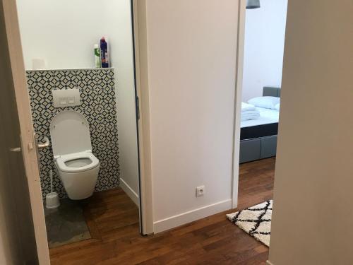 ein Bad mit einem WC in einem Zimmer mit einem Bett in der Unterkunft Superbe T2 en bords de Saône in Gray