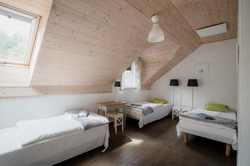 a attic bedroom with two beds and a table at Zielone Wzgórze in Sulistrowiczki