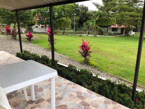 a white table sitting on a patio with a garden at Cabañas Campestres en Villavicencio in Villavicencio