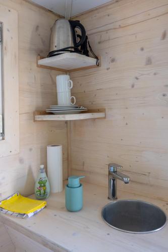 a kitchen counter with a sink and a lamp at Baumhaus - Tiny Haus in der Höhe in Erkheim