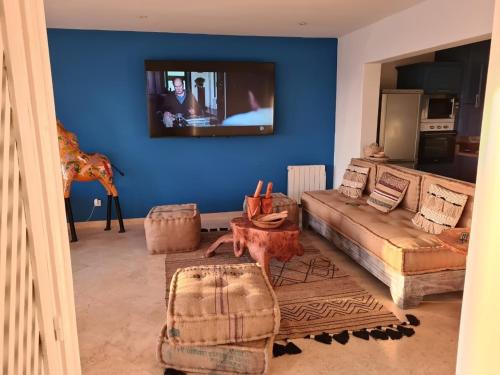 a living room with a couch and a tv on a blue wall at La Skala - Apartment with great sea view in Essaouira