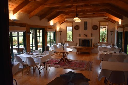 a dining room with tables and chairs and a fireplace at The River Lodge in Ohakune