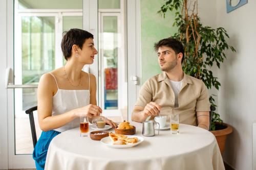 a man and woman sitting at a table eating food at New Bristol Sport Hotel in Cesenatico