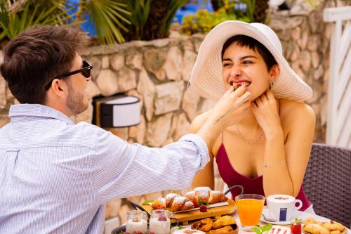 a man feeding a woman at a table with food at New Bristol Sport Hotel in Cesenatico