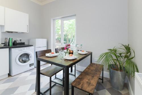 a kitchen with a table and chairs and a washing machine at The Linden Grove Apartments in Nottingham
