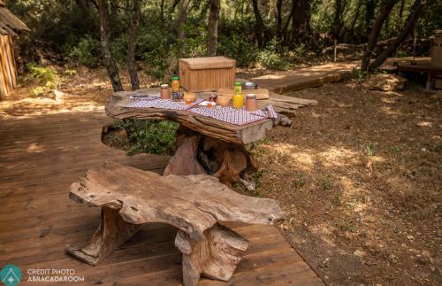 a picnic table made out of logs with food on it at Sortilège in Lambesc