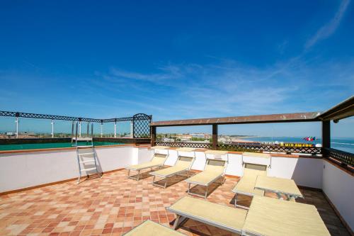 a balcony with chairs and a ladder on a building at New Bristol Sport Hotel in Cesenatico