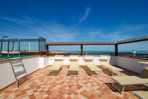 a group of chairs and tables on a balcony at New Bristol Sport Hotel in Cesenatico