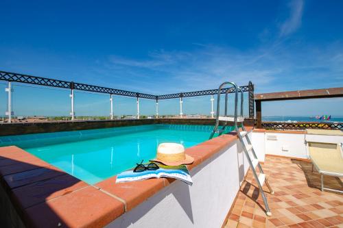 a hat is sitting on the edge of a swimming pool at New Bristol Sport Hotel in Cesenatico