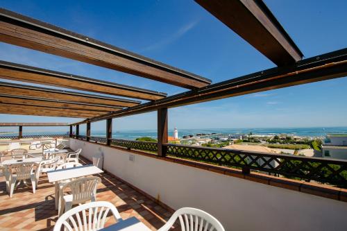 a balcony with tables and chairs and a view of the ocean at New Bristol Sport Hotel in Cesenatico