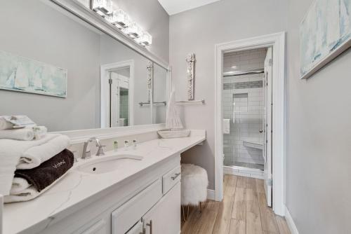 a white bathroom with a sink and a mirror at Phoenix 6 Unit 114 in Orange Beach