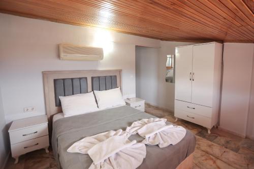 a bedroom with a bed with a wooden ceiling at Ciftlik Hotel in Çeşme