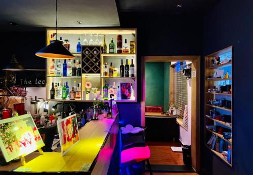 a room with a bar with a table and a shelf at Guilin Cyan Box Guest House in Guilin