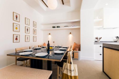 - une cuisine et une salle à manger avec une table et des chaises dans l'établissement PAMPA  KEYWEEK Maison de ville terrasse Biarritz Beaurivage, à Biarritz