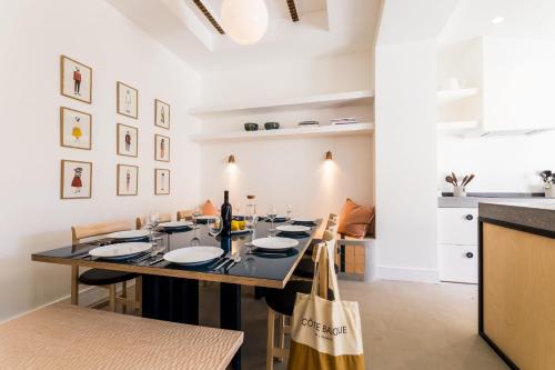 ビアリッツにあるPAMPA KEYWEEK Town house with terrace in Biarritzのテーブルと椅子のあるキッチンとダイニングルーム