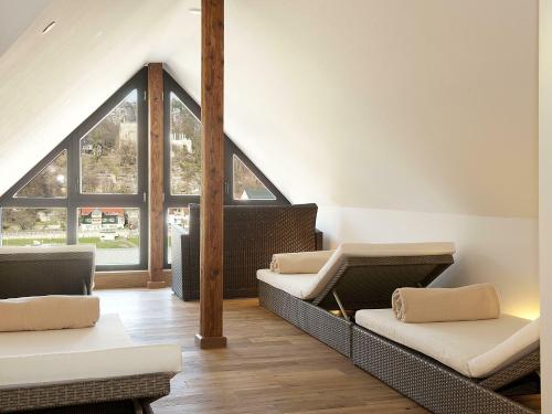 ein Wohnzimmer mit 2 Sofas und einem großen Fenster in der Unterkunft Hotel Ettrich & Elbresort Rathen in Kurort Rathen