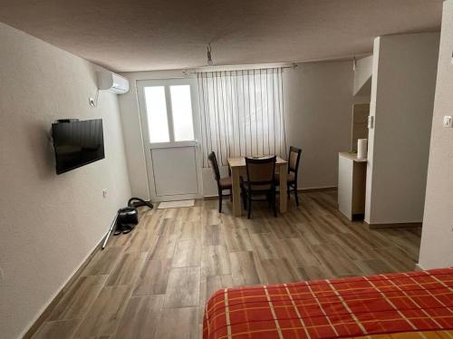 a room with a table and chairs and a television at Apartmani Mihajlović in Herceg-Novi
