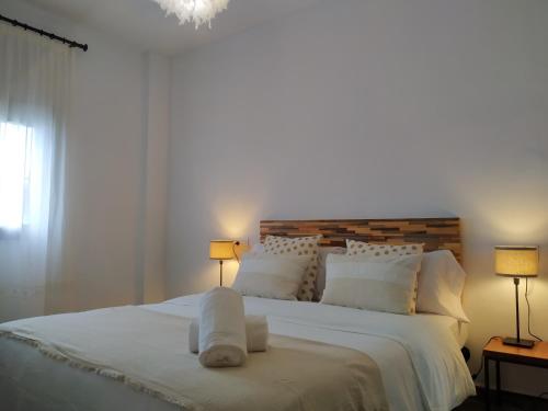 a bedroom with a large white bed with two lamps at Atalaya de los Bermejales Villa privada piscina in Los Morales