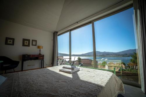 a bedroom with a bed and a large window at aMaRe Country House in Caminha