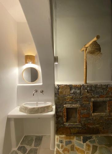 a bathroom with a sink and a stone wall at Beachhouse Omega Naxos in Agia Anna Naxos