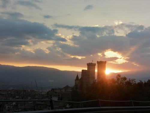 una puesta de sol sobre una ciudad con un castillo en Casa Fonte Vallone, en Pacentro