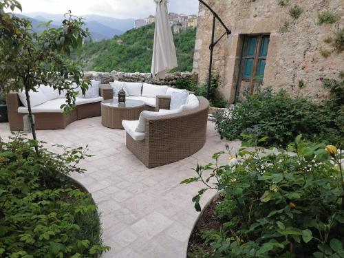 un patio con 2 sofás y una mesa en Casa Fonte Vallone, en Pacentro