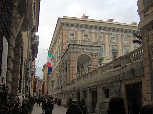 people walking down a street in front of a building at San Giorgio Rooms in Genova