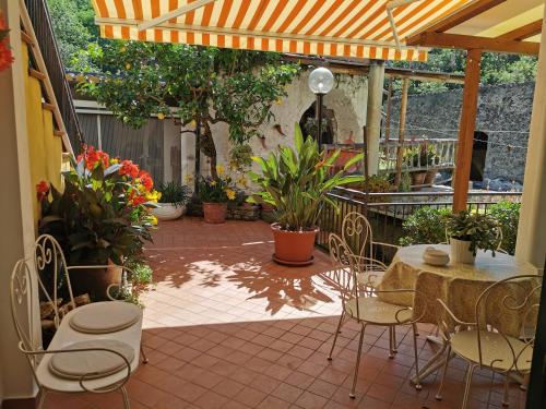 a patio with a table and chairs and plants at "Lemon Tree House" Relax&Bike in campagna a Finale Ligure con Air Cond in Orco Feglino