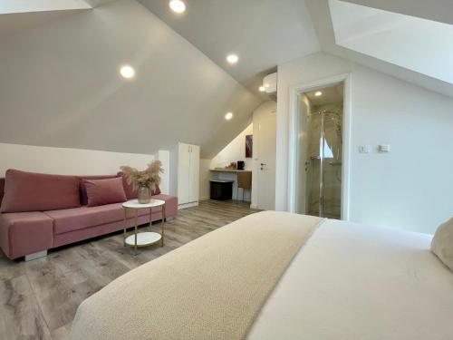 a bedroom with a bed and a pink couch at Ida Old Town Rooms 2 in Dubrovnik