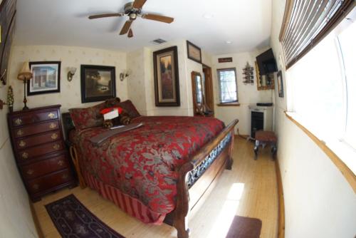 a bedroom with a bed and a ceiling fan at FLEUR DE LAC EUROPERAN INn in Lake Arrowhead