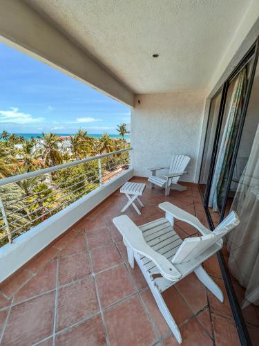 a balcony with chairs and a view of the ocean at Hotel California Playa El Yaque in El Yaque