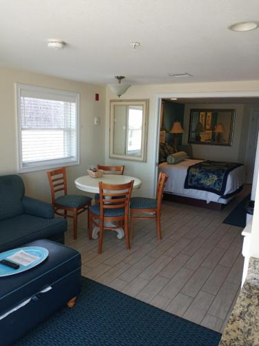 a living room with a bed and a table and chairs at Ocean Club on Smuggler's Beach in South Yarmouth