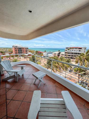 a balcony with chairs and a view of the beach at Hotel California Playa El Yaque in El Yaque