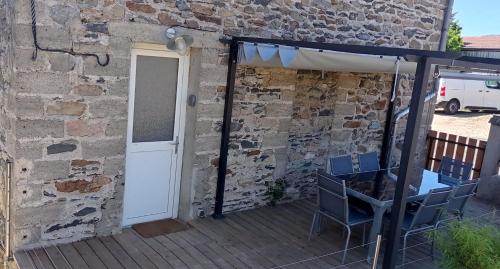 a patio with chairs and an umbrella and a building at Git'a'Gnac in Retournac