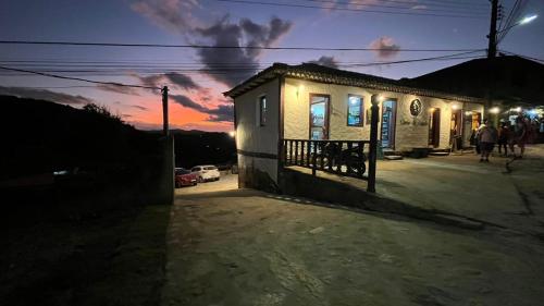a small building with a sunset in the background at Chalés Ouro de Minas in Conceição da Ibitipoca